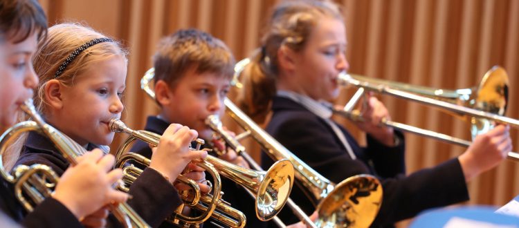 Group of pupils playing brass instruments in Cedars Hall at our Independent Prep School in Somerset